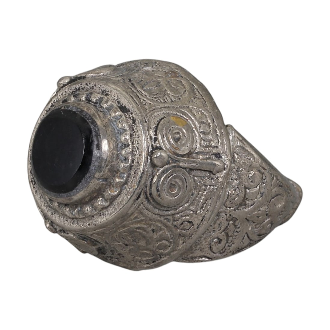 A Middle Eastern Silver Plated Onyx Ring, Late 19th-Early 20th Century, 25AK: The ring is centered with a round cabochon onyx stone set within a domed bezel framed by a raised beaded border. The bezel and shoulders are engraved with stylized spiral and foliate motifs. The silve