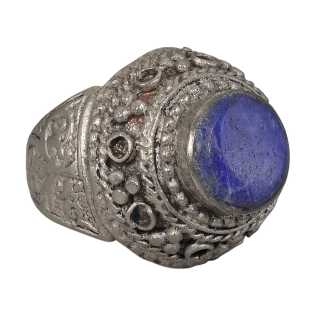 A Middle Eastern Silver Plated Lapis Lazuli Ring, Late 19th-Early 20th Century, 8AK: The ring is centered with a round cabochon lapis lazuli stone exhibiting deep blue color and natural pyrite flecks, set within an ornate domed bezel decorated with beaded granulation, twisted wirework