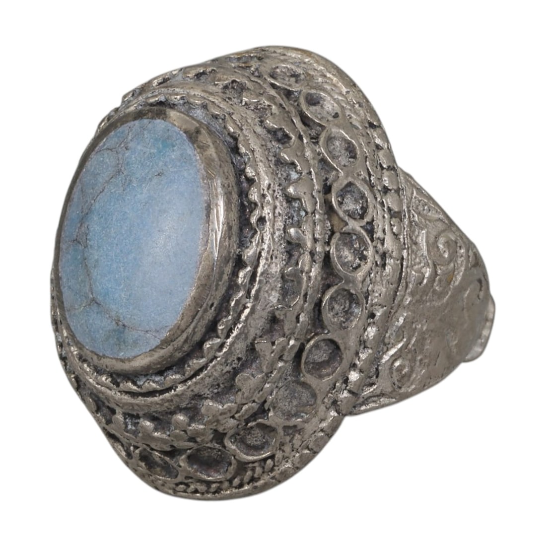 A Middle Eastern Silver Plated Turquoise Ring, Late 19th-Early 20th Century, 40AK: The ring is centered with an oval cabochon turquoise stone exhibiting light blue color and natural surface veining, set within a domed bezel decorated with openwork circular patterns and floral motifs