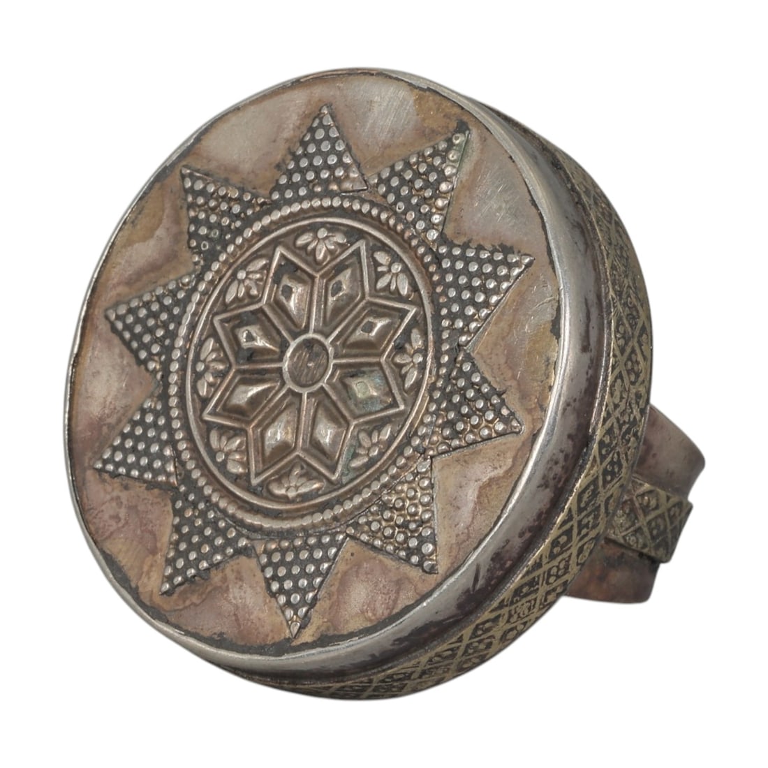 A Central Asian Silver Plated Geometric Star Motif Ring, Late 19th-Early 20th Century, 12AK: Crafted from silver plated metal with brass accents, featuring a wide, open band. The circular bezel displays a multi-layered star motif: a central eight-pointed star surrounded by small floral detail