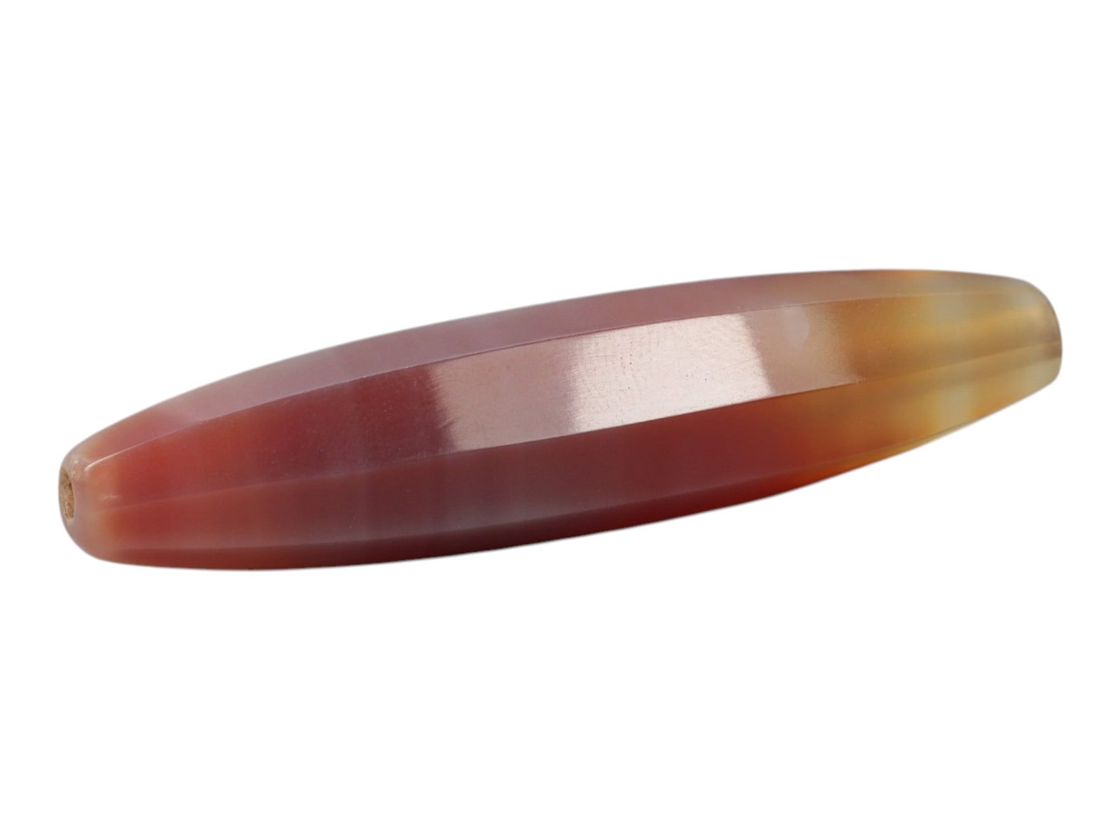 Antique Agate Faceted Bead - Idar Oberstein, 20WS: A faceted carnelian agate bead, crafted in Idar-Oberstein. The bead exhibits a natural colour gradient, transitioning from deep red to translucent orange-yellow, with fine parallel banding visible wit