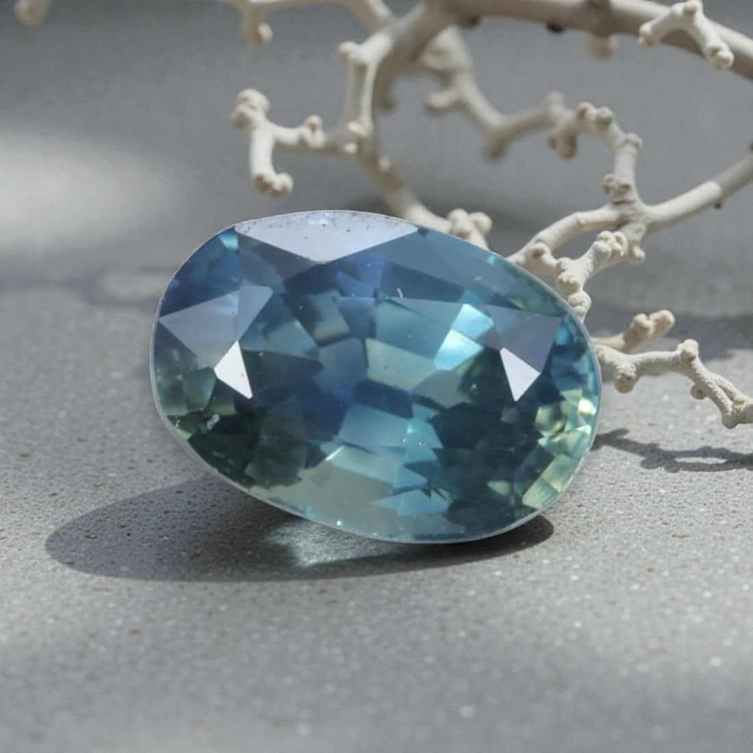 0.88 Carats Natural Australian Parti Sapphire Oval Cut, 34AL: This oval-cut natural sapphire showcases a stunning parti color palette, blending soft teal-blue and subtle green hues that shift beautifully under light. The faceted cut features well-proportioned fa