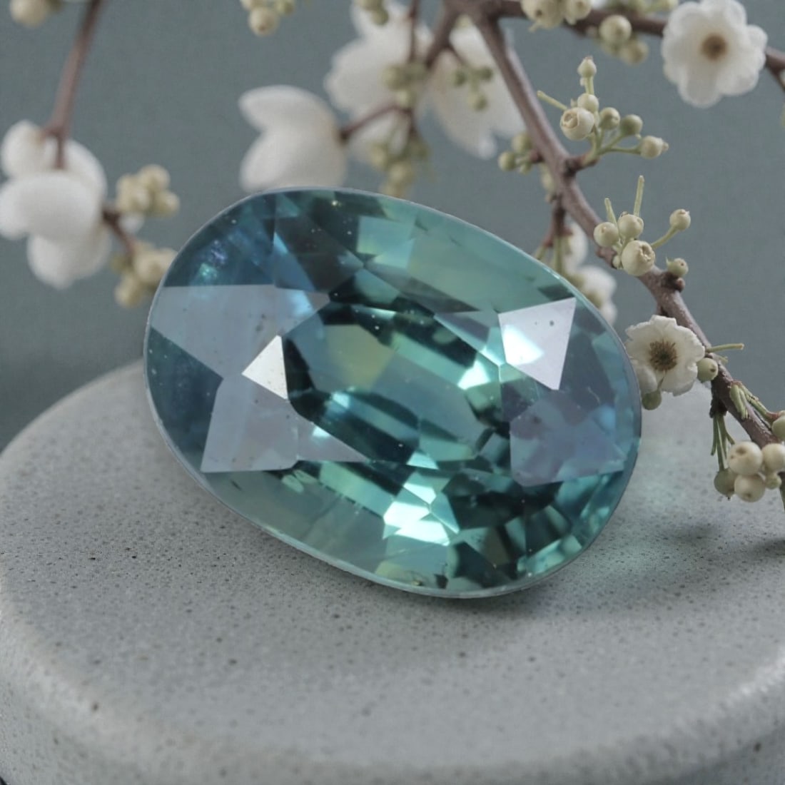 1.12 Carats Natural Australian Parti Sapphire Oval Cut, 32AL: This oval-cut natural sapphire showcases a stunning parti color palette, blending soft teal-blue and subtle green hues that shift beautifully under light. The faceted cut features well-proportioned fa