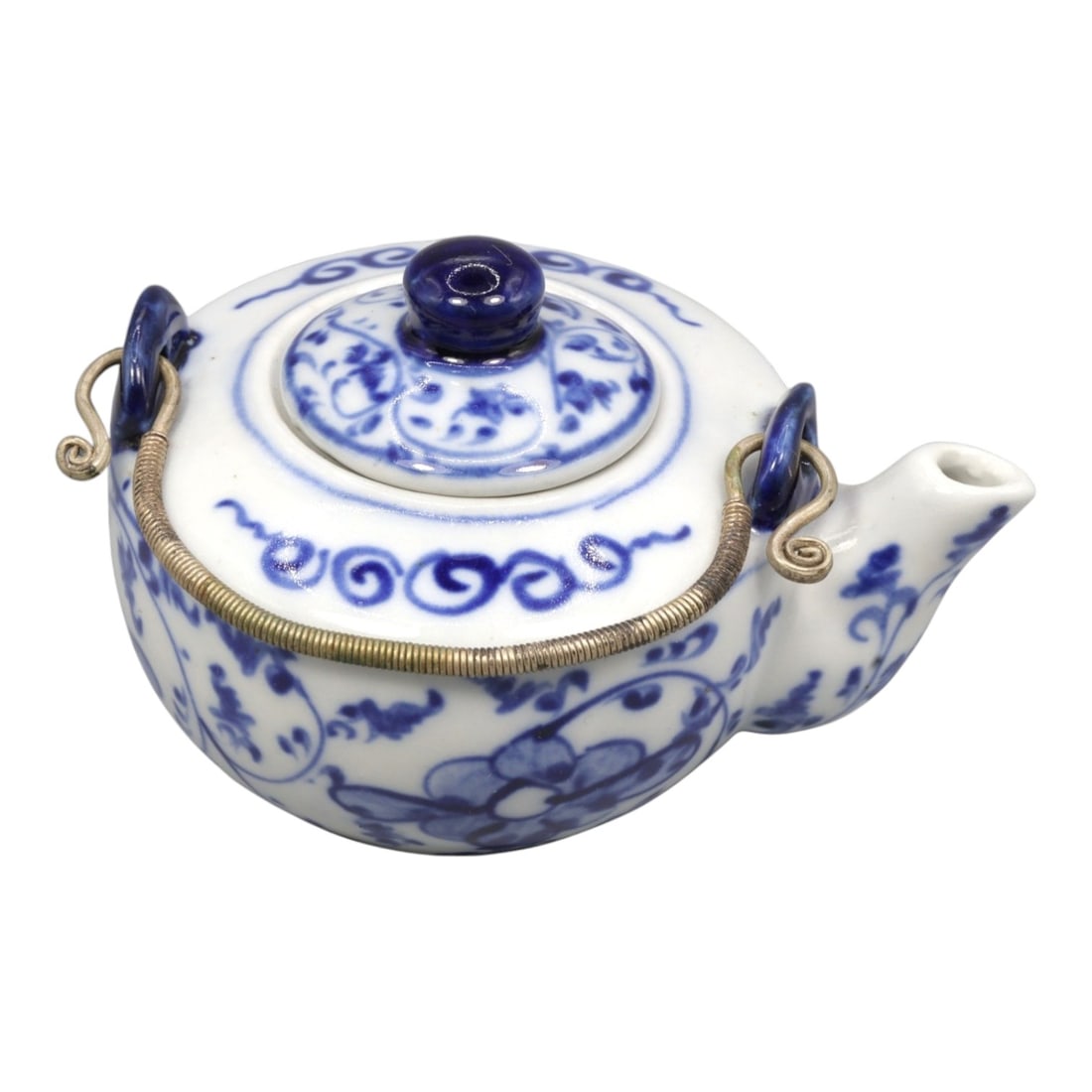 A Chinese Blue and White Porcelain Teapot, 20th Century, 52FK: The teapot is formed with a compressed globular body resting on a short foot, fitted with a domed cover surmounted by a circular knop, and equipped with a short projecting spout and a metal swing hand