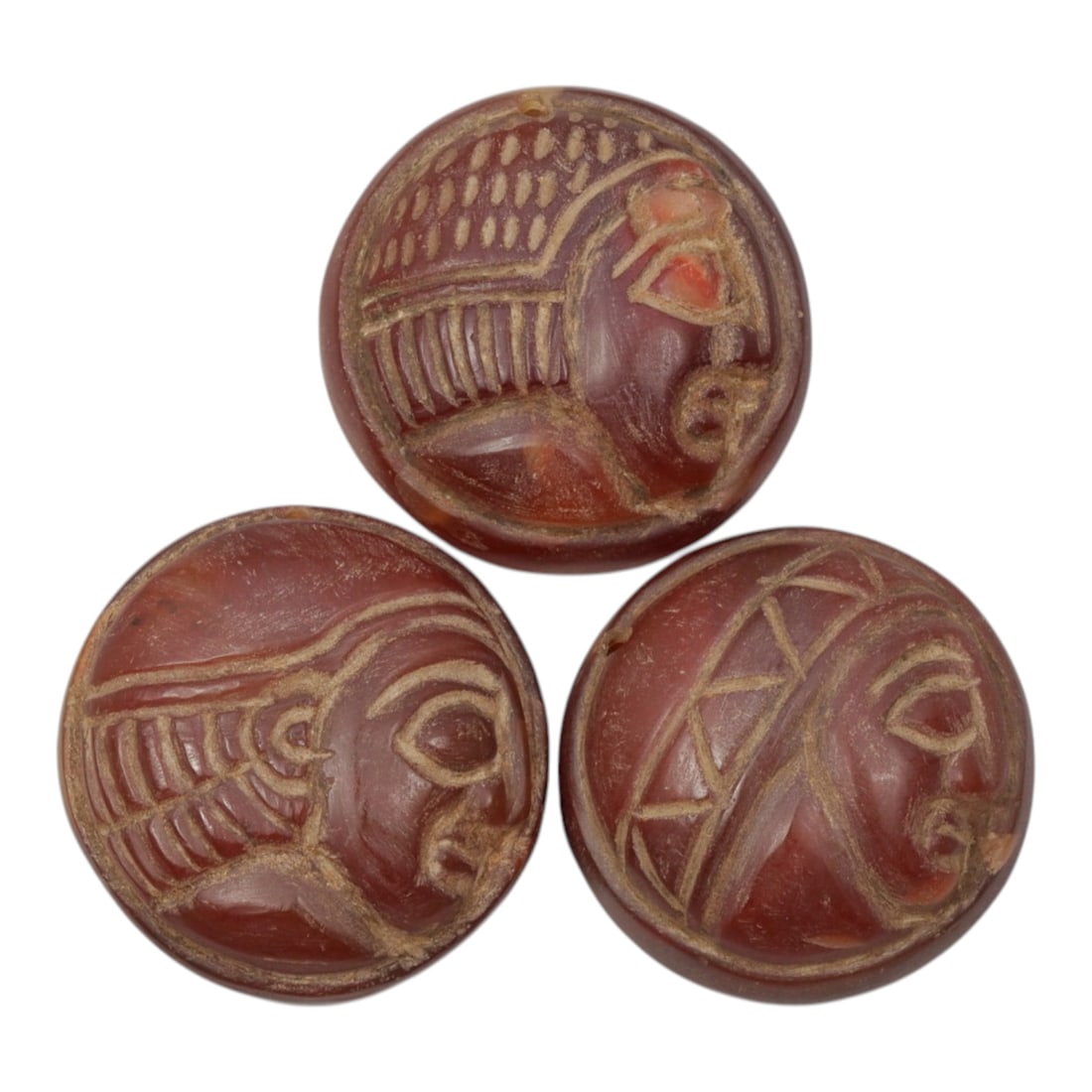 Lot of 3 Ancient Coptic Egyptian Carnelian Face Beads, Circa Roman to Coptic Era, 53WM: A curated lot of three ancient Coptic Egyptian-style beads, carved from natural carnelian stone with rich reddish-brown hues and natural patina consistent with age. Each circular bead features incised