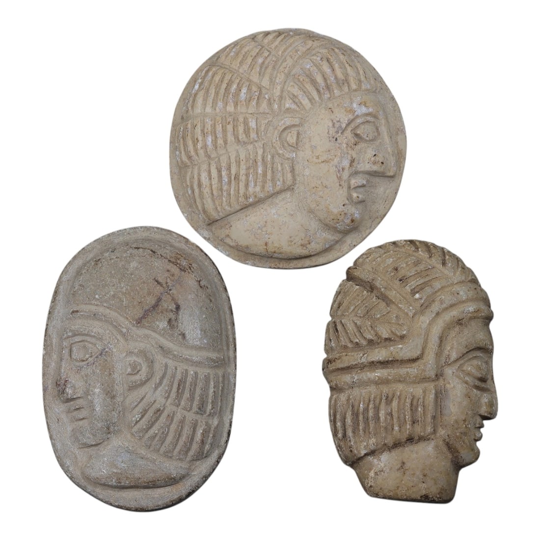 Lot of 3 Ancient Coptic Egyptian Steatite Face Beads / Amulets, Circa Roman to Coptic Era, 23AE: Comprising three finely carved steatite face amulets ranging from 4.5 cm to 5 cm, these pieces are characteristic decorative and protective jewelry from the Coptic Egyptian period. Each is rendered in