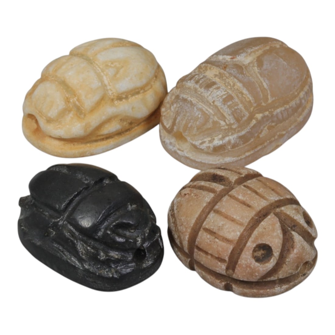 Lot of 4 Ancient Coptic Egyptian Multi-Stone Scarabs, Circa Roman to Coptic Era, 93WT: Carved from various stones in light beige, translucent, dark black, and earth-toned hues, the group consists of four distinct scarab amulets. Each piece features the characteristic scarab form with in