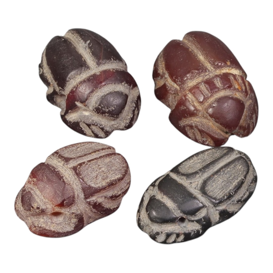 Lot of 4 Ancient Coptic Egyptian Carnelian Scarab Amulets, Circa Roman Period to Coptic Era, 92AD: Comprising four scarab amulets ranging from 1.5 cm to 2 cm, these pieces are characteristic protective talismans from the Coptic Egyptian period. Three are carved from deep red and reddish-brown carne
