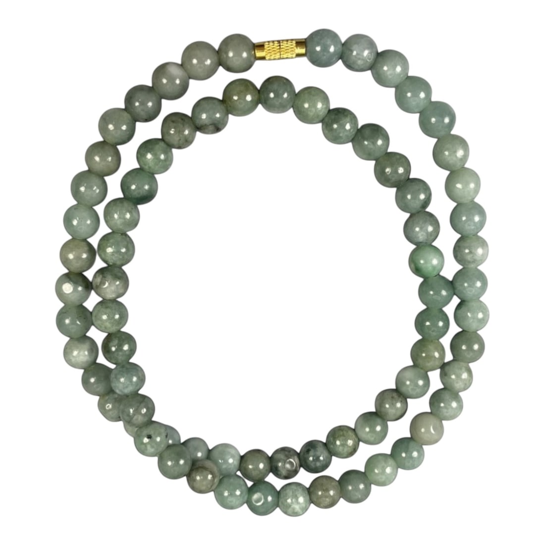 A Chinese Jadeite Jade Bead Necklace, 20th Century, 60ZK: Composed of spherical beads of pale to medium green jadeite jade with natural veining and subtle tonal variations, the necklace is strung in a continuous loop. The beads exhibit a smooth, polished sur
