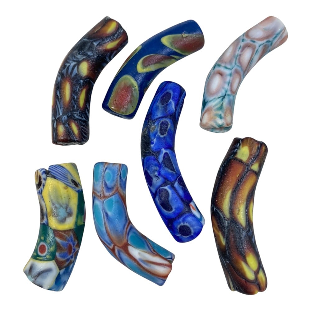 A Lot of 7 Vintage Mosaic Glass Curved Beads, 88AA: The group comprises seven curved tubular beads, each formed from polychrome mosaic glass. The glass is composed of fused millefiori segments arranged in distinct repeating patterns, including circular