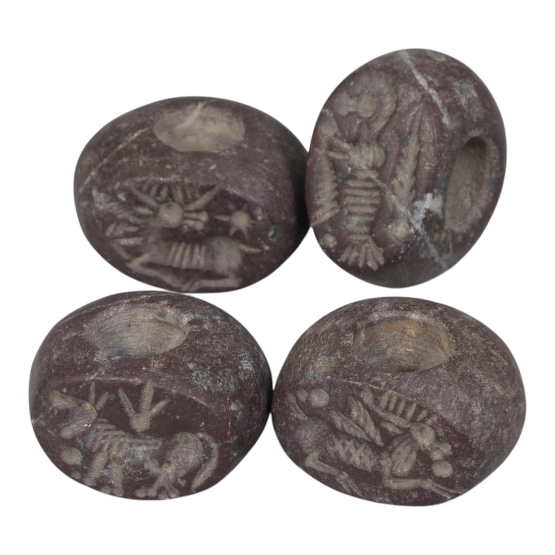 Lot of 4 Ancient Sasanian Stone Stamp Seals, Circa 3rd-7th Century CE, 67WP: A collection of four Sasanian period stamp seals, carved from reddish stone, each with a central drilled hole for suspension. The seals are decorated with characteristic Sasanian zoomorphic motifs, in