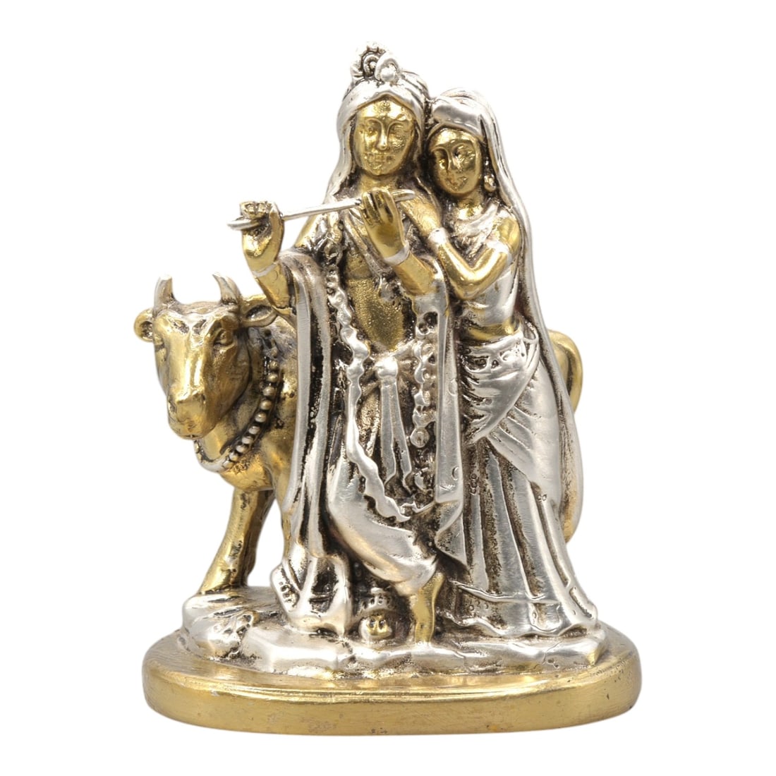An Indian Metal Figure of Krishna and Radha, 20th Century, 14YD: Cast in metal and finished with contrasting silver- and gold-toned surfaces, the figure represents Krishna standing beside Radha, accompanied by a cow positioned at the proper left. Krishna is shown p