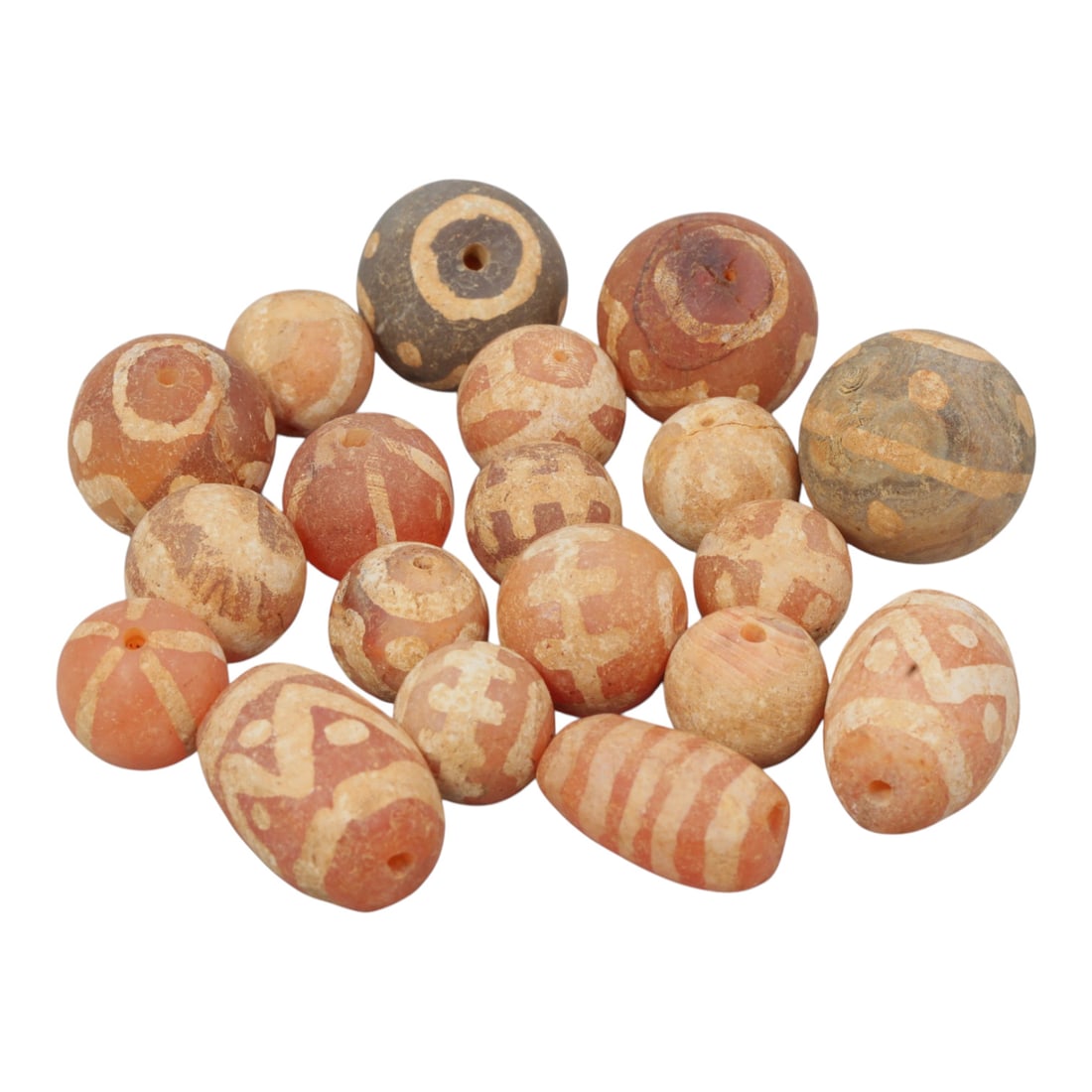Lot of 19 Ancient Etched Carnelian Beads, Gandhara Period, 21WM: A group of 19 ancient etched carnelian beads from the Gandhara period. The beads are of varying round, oval, and slightly tapered forms, crafted primarily from reddish-orange carnelian, with some grey