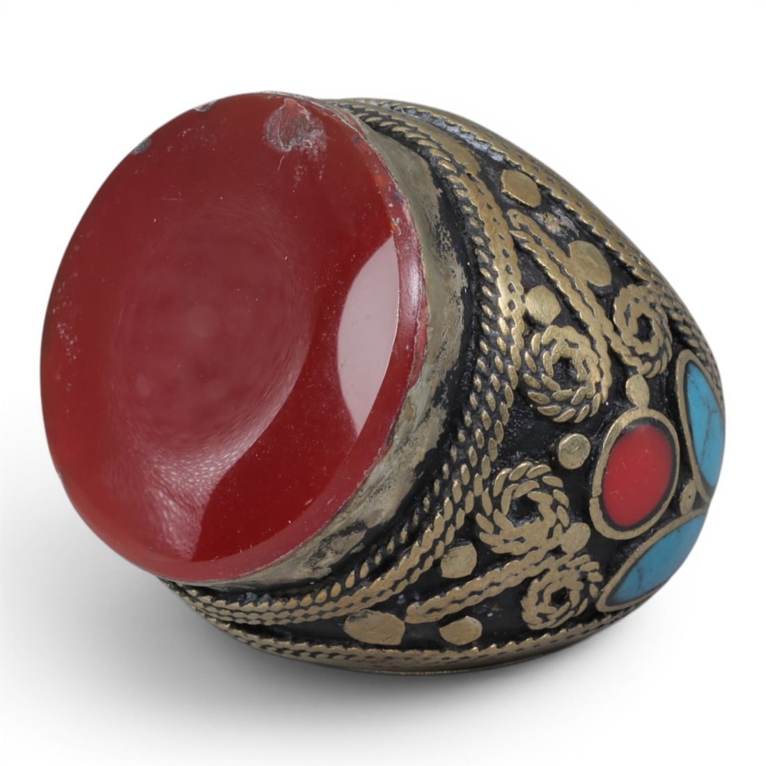 Antique Central Asian Silver and Carnelian Tribal Ring, 19th-Early 20th Century, 67AJ: The ring is set with a large, smooth cabochon carnelian stone, exhibiting minor surface wear. The silver mount is decorated with pseudo-filigree wirework, applied coiled motifs, and inlaid turquoise a