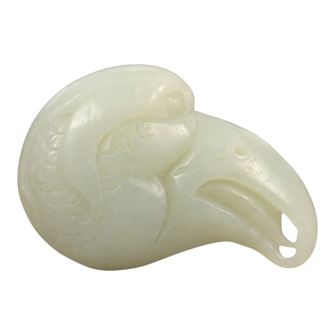 A Chinese Nephrite Jade Bird-Head Ornament, 20th Century, 30FA: Carved from pale celadon nephrite jade with even translucency and minor natural inclusions, the object is worked in the form of a stylized bird's head shown in profile. The rounded cranial form transi