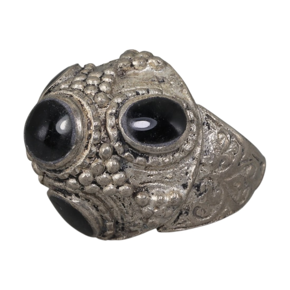 A Middle Eastern Silver Plated Multi-Stone Onyx Ring, Late 19th-Early 20th Century, 34AK: The ring features multiple round and oval cabochon onyx stones set within an ornate domed bezel decorated with raised granulation. The bezel and shoulders are engraved with scrolling foliate motifs. T