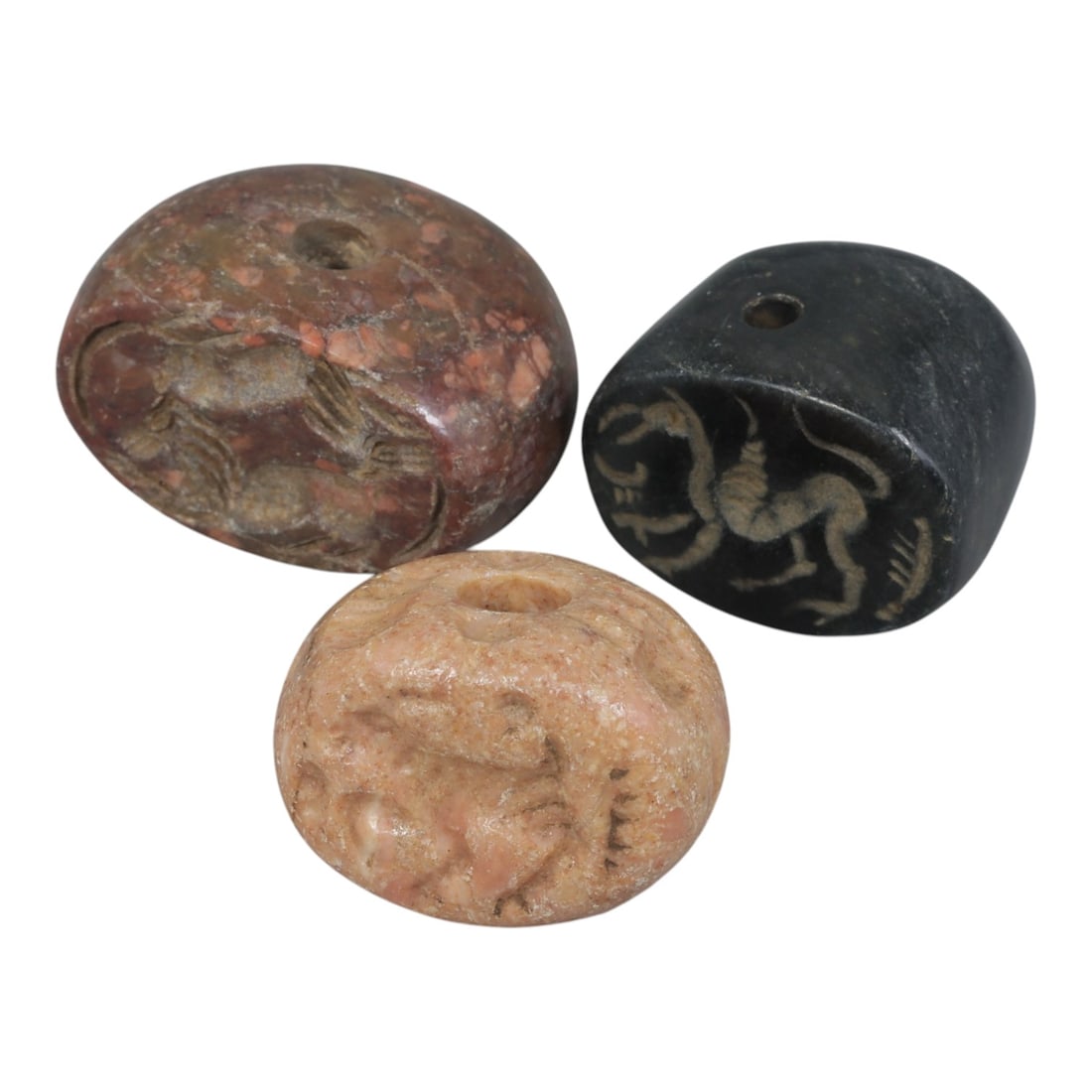 Lot of 3 Ancient Sasanian Stone Stamp Seals, Circa 3rd-7th Century CE, 68WP: A collection of three Sasanian period stamp seals, carved from varied stone types including dark grey, light pinkish, and reddish mottled stone, each featuring a central drilled hole for suspension. T