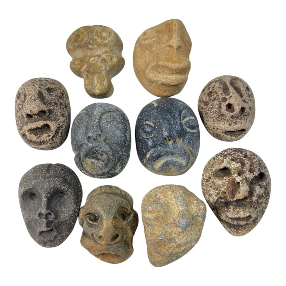 A Lot of 10 Ancient Medieval Stone Maskette Amulets, 4AB: The group comprises ten carved stone maskette amulets, each depicting stylized human or zoomorphic faces. The pieces are rendered in varied styles, some with deeply carved features and others with sch