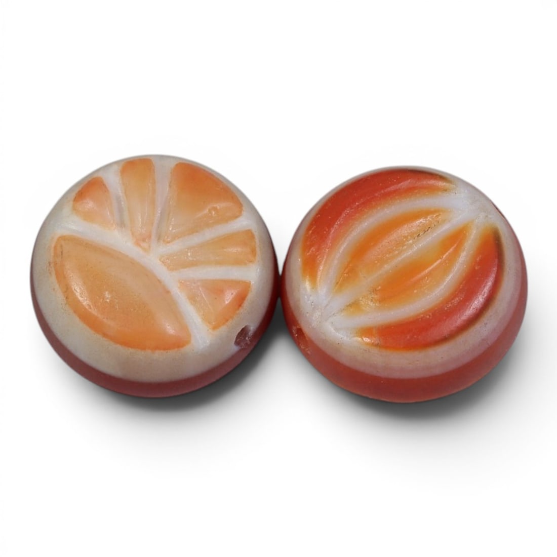 A Pair of Antique Himalayan Banded Carnelian Beads, 74AJ: The pair consists of two round, flat carnelian beads, each displaying distinct natural banding patterns. One bead features fan-like orange and white striations, while the other shows curved, eye-like 