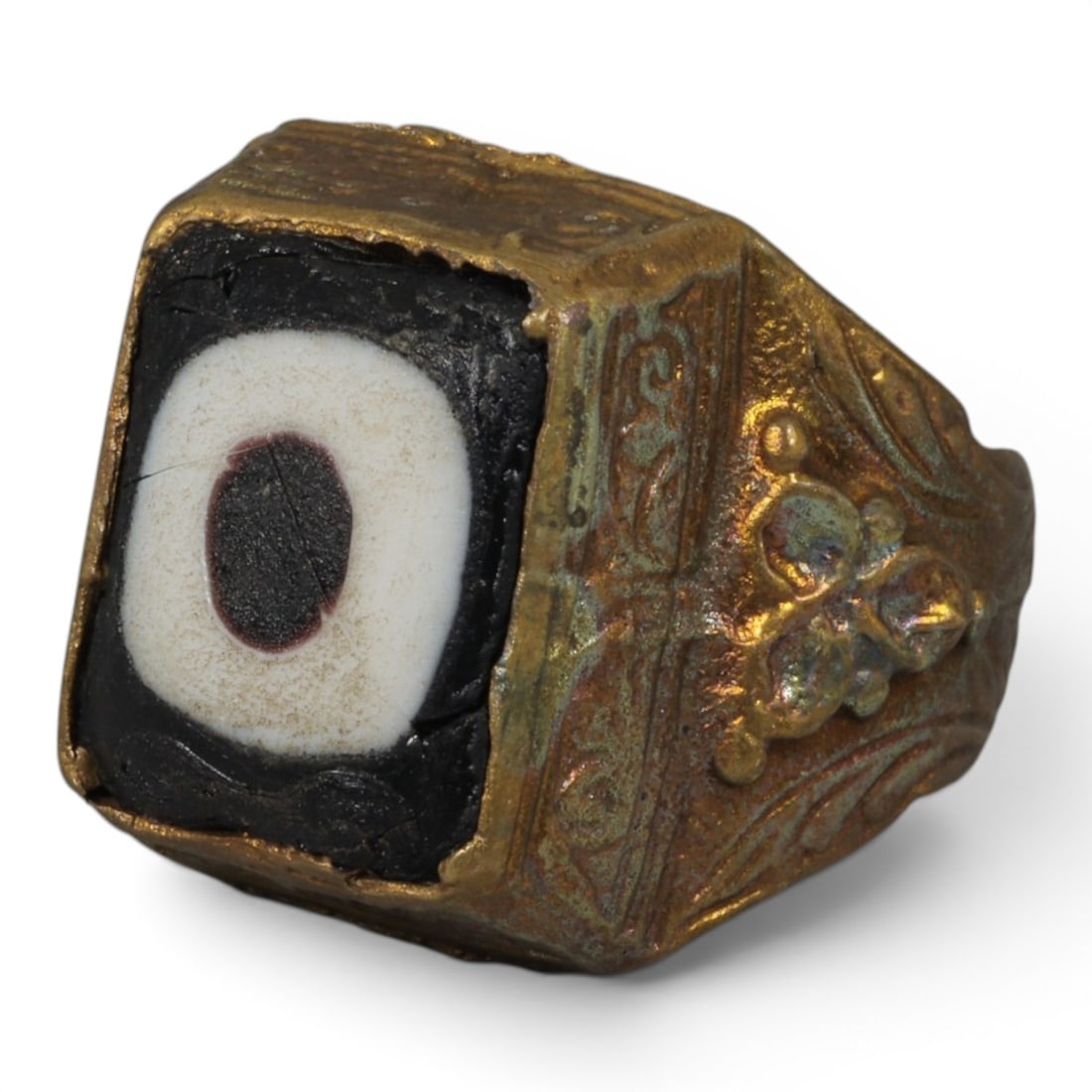 Antique Qajar Dynasty Gilt Evil Eye Ring, US Size 10, 49AJ: A gilt-metal ring of the Qajar period, US ring size 10, featuring a large square evil-eye glass inlay with a bold concentric black, white, and dark central design (the glass exhibits age-related crack