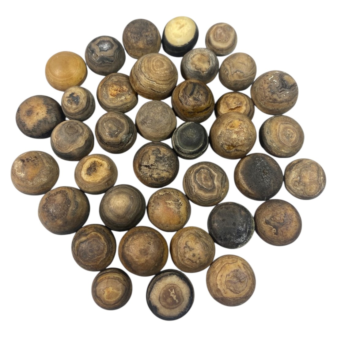 Lot of 37 Antique Tibetan Luk Mik Goat Eye Agate Beads, 40AC: A collection of thirty-seven spherical agate beads, known as luk mik or goat eye beads, each exhibiting natural concentric banding patterns in earthy tones of brown, grey, and tan. Many examples displ