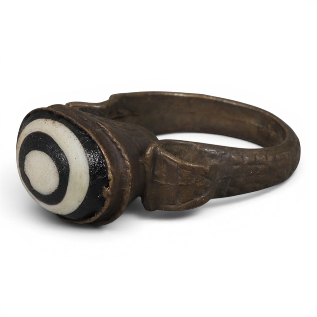 Antique Qajar Dynasty Bronze Evil Eye Ring, US Size 9, 19AJ: A bronze ring of the Qajar period, US ring size 9, featuring a domed evil-eye glass inlay with a striking concentric black-and-white pattern. The glass exhibits age-related patina and wear consistent 