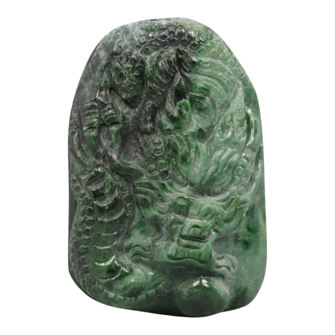 A Chinese Jadeite Jade Pendant, 20th Century, 26ZL: Carved from green jadeite jade with natural dark green and greyish inclusions distributed throughout the matrix, the pendant is formed as an irregularly rectangular object with a relief-carved dragon 