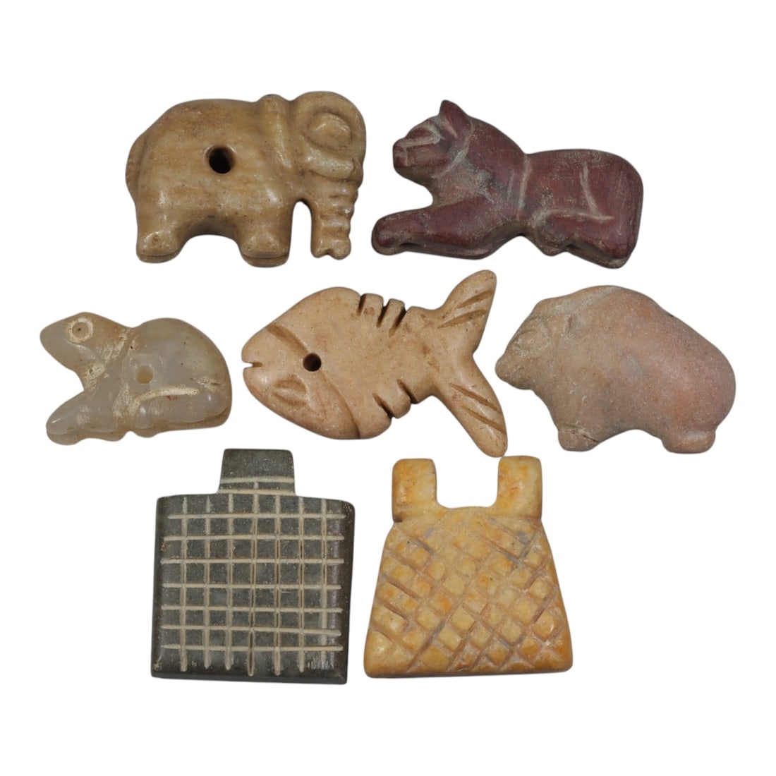 Lot of 7 Ancient Coptic Egyptian Multi-Stone Amulets, Circa Roman to Coptic Era, 94AH: Carved from various earth-toned stones including light beige marble, reddish-brown stone, translucent quartz, and dark grey varieties, the group consists of seven distinct amulets, ranging in size fro