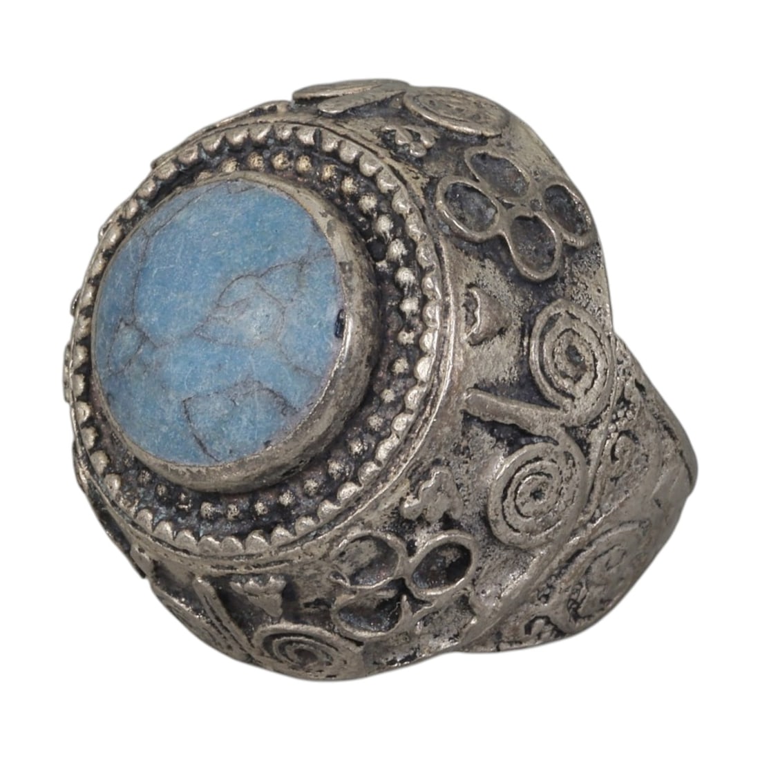 A Middle Eastern Silver Plated Turquoise Ring, Late 19th-Early 20th Century, 16AK: The ring is centered with a round cabochon turquoise stone exhibiting characteristic light blue color and natural surface veining, set within a domed bezel framed by beaded granulation. The bezel and 