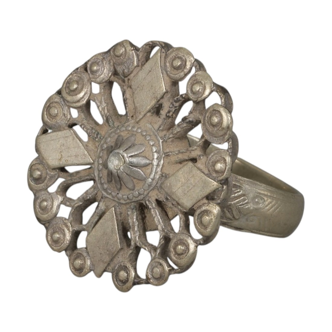A Berber Silver Openwork Floral Motif Ring, Late 19th-Early 20th Century, 41AK: Crafted from silver, featuring a rounded band with subtle incised geometric detailing. The circular bezel displays an openwork design centered on a floral motif, surrounded by radiating elements and a
