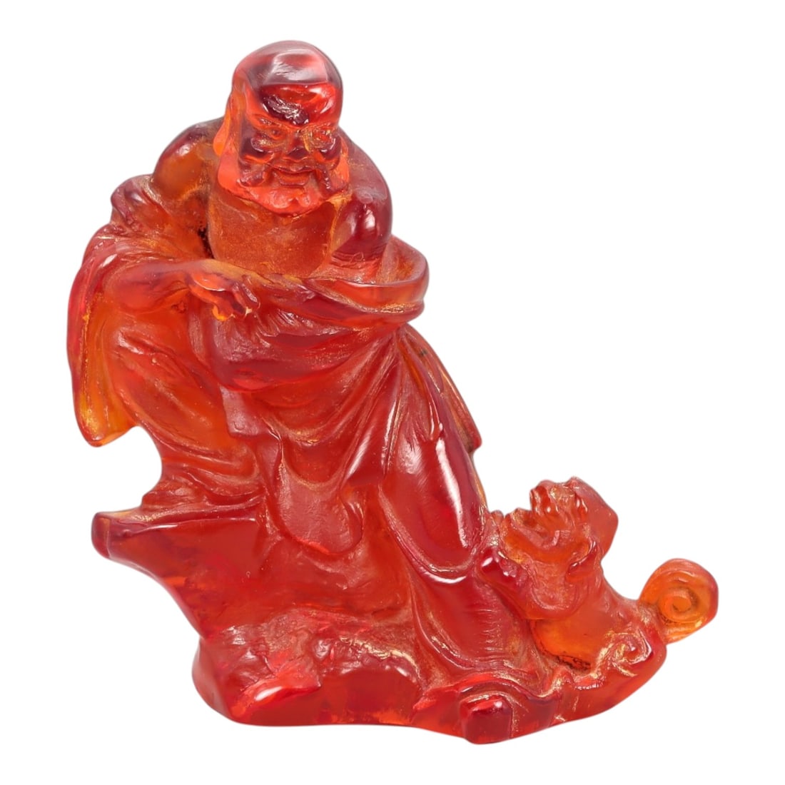 A Chinese Amber-Resin Figure of a Luohan, 20th Century, 40FH: Cast or carved from translucent amber-colored red resin with internal tonal variation and minor inclusions, the figure represents a standing luohan accompanied by a small attendant or symbolic creatur