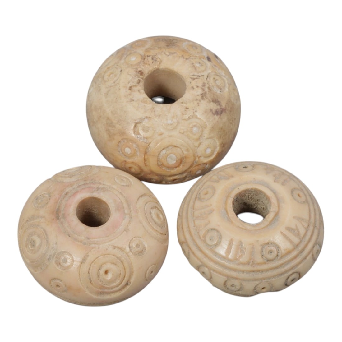 A Lot of 3 Ancient Silk Road Bone Spindle Whorls, 96WK: Three spherical bone spindle whorls, each featuring a central perforation intended for mounting on a spindle shaft. The surfaces are decorated with incised concentric circle motifs, a common design on