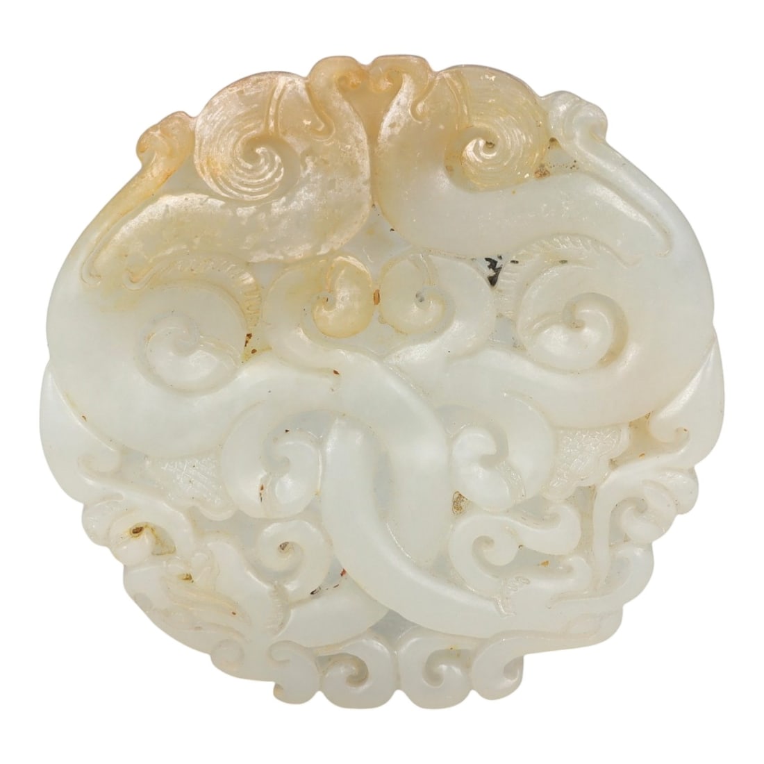 A Chinese Hetian Jade Cloud-Form Plaque, 20th Century, 68FH: Carved from pale celadon Hetian nephrite jade with soft translucency and scattered natural inclusions, the plaque is worked as a rounded form with a gently lobed outline. The surface is carved in low 