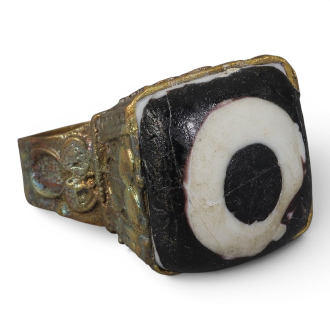 Antique Qajar Dynasty Gilt Evil Eye Ring, US Size 9.5, 43AJ: A gilt-metal ring of the Qajar period, US ring size 9.5, featuring a large square evil-eye glass inlay with a bold concentric black-and-white design (the glass exhibits age-related cracks). The bezel 