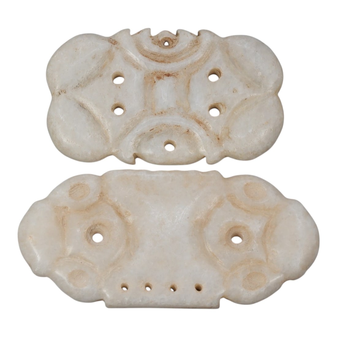 Lot of 2 Ancient Near Eastern Marble Ornamental Amulets, c. Iron Age to Sasanian Period, 93WK: A pair of finely carved marble ornamental plaques from the Ancient Near East, featuring symmetrical geometric designs with multiple perforations for suspension. Crafted from smooth white marble with s