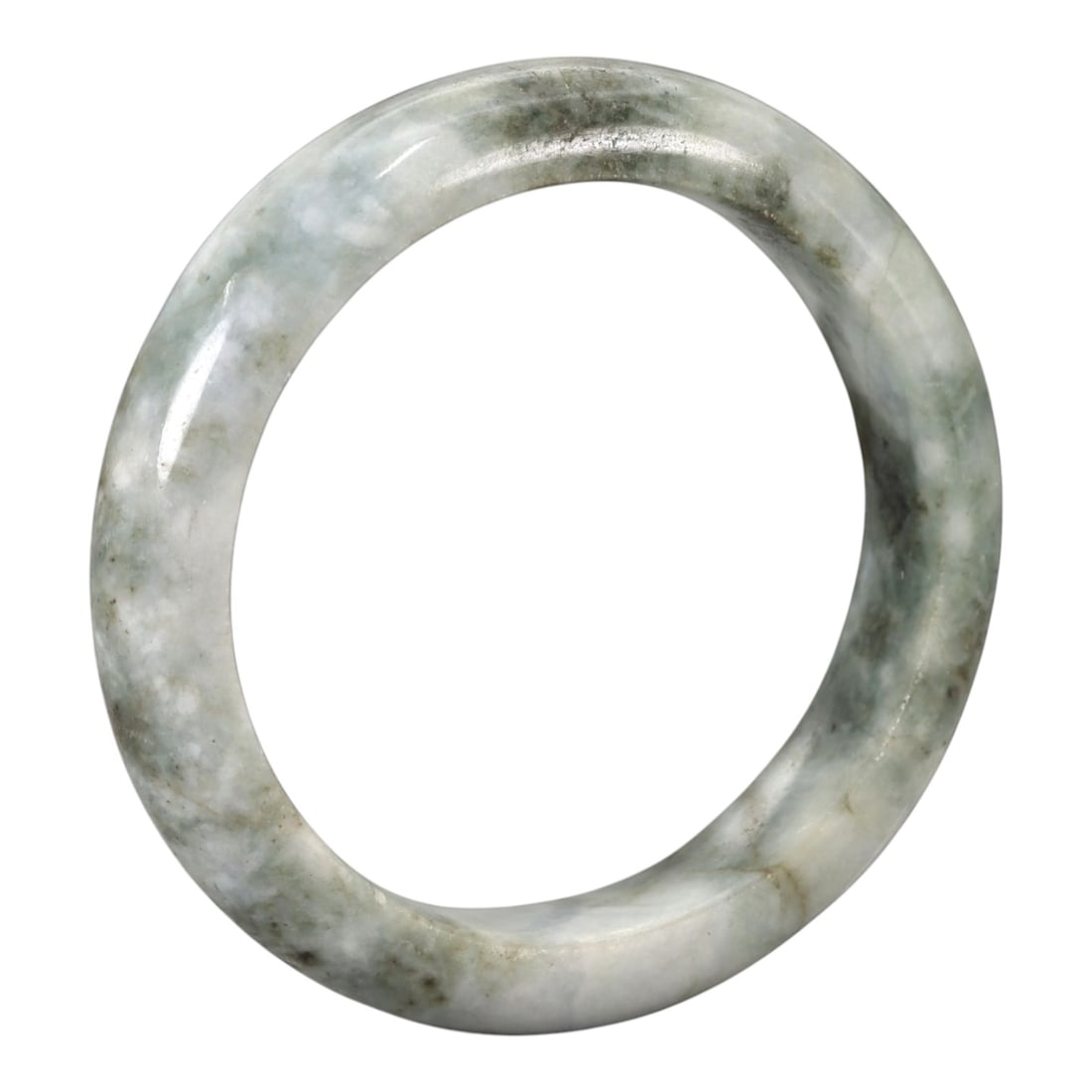 A Chinese Jadeite Jade Bangle Bracelet, 20th Century, 92ZK: Carved from jadeite jade with a pale white base and irregular greyish-green mottling, the bangle is formed as a continuous circular band with a rounded cross-section. The surface is smoothly polished,