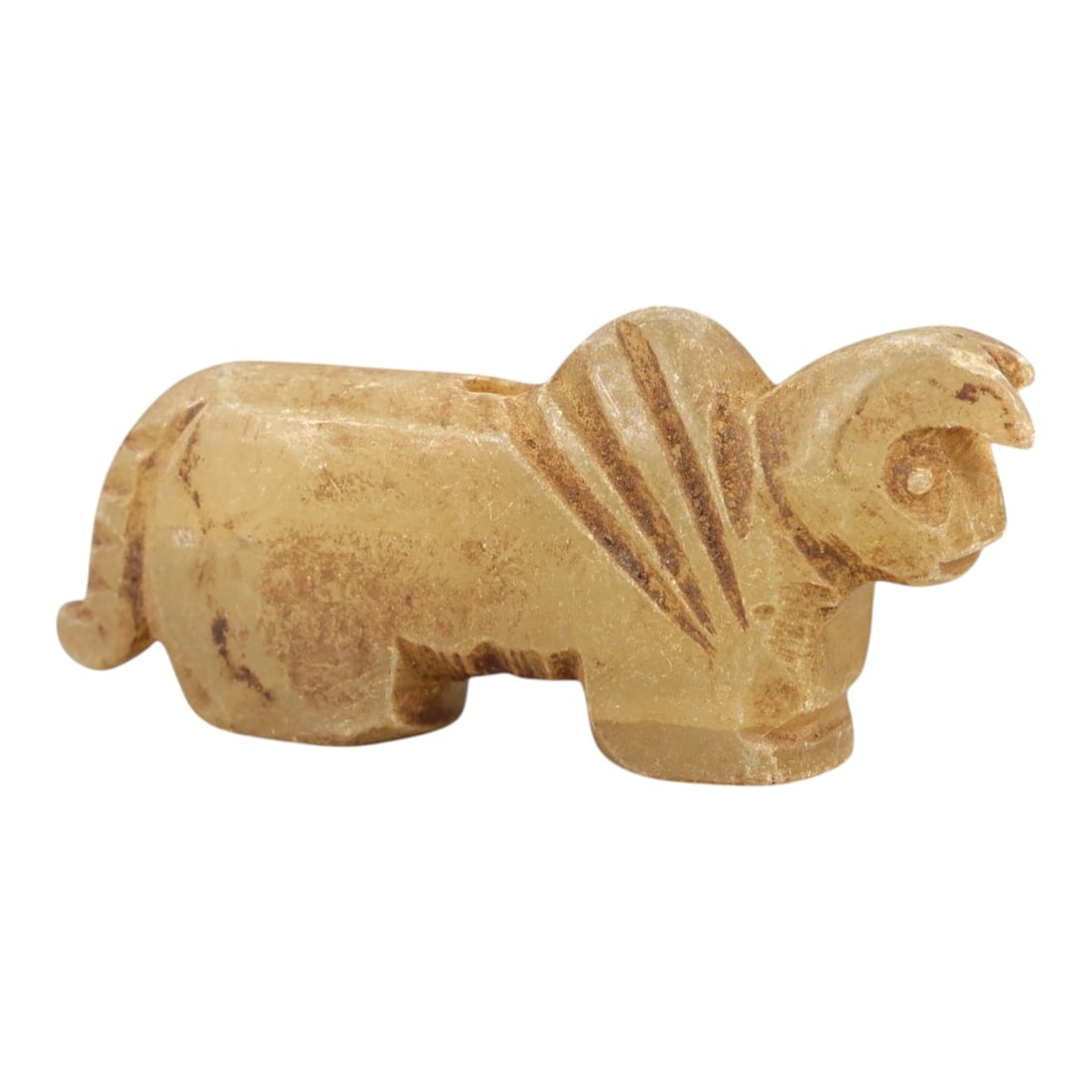 Ancient Rock Crystal Bovid Amulet - Near Eastern Figurine, 87AL: Carved from translucent pale yellow rock crystal, this amulet depicts a stylized recumbent bovid, likely a ram or sheep, with incised linear patterns along the neck and back to denote fur or mane. The