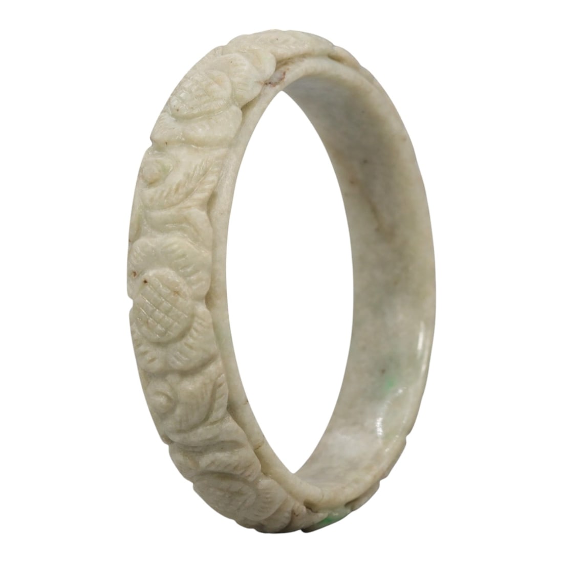 A Chinese Carved Jadeite Jade Bangle Bracelet, 20th Century, 28ZL: A fine jadeite bangle of flattened circular form, masterfully carved in relief with a continuous band of peony blossoms and interlocking foliate motifs. The stone features a predominantly creamy white
