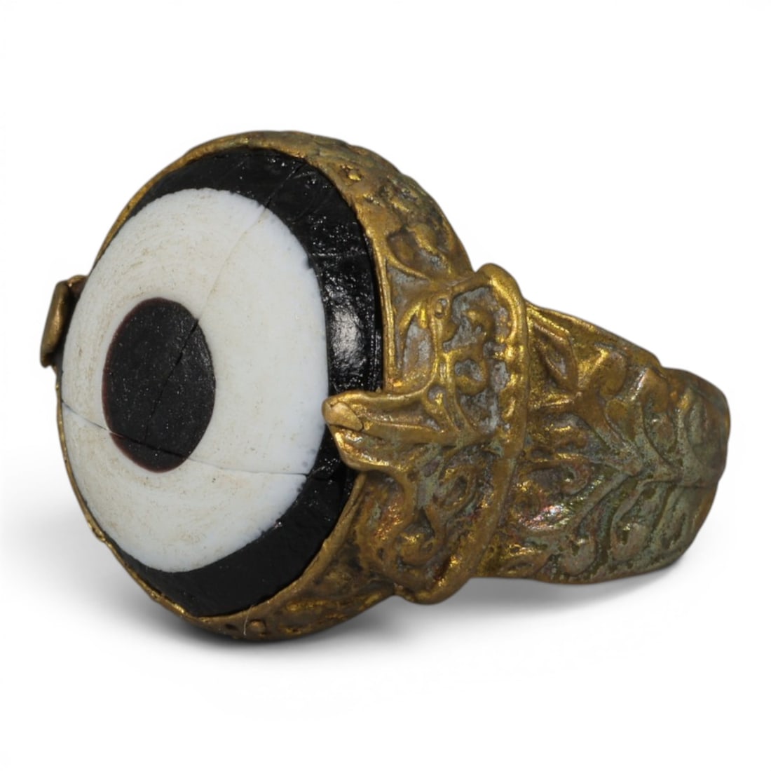 Antique Qajar Dynasty Gilt Evil Eye Ring, US Size 8.5, 27AJ: A fine gilt-metal ring of the Qajar period, US ring size 8.5, featuring a large central evil-eye glass inlay with a classic black, white, and dark red concentric design. The bezel is secured with deco