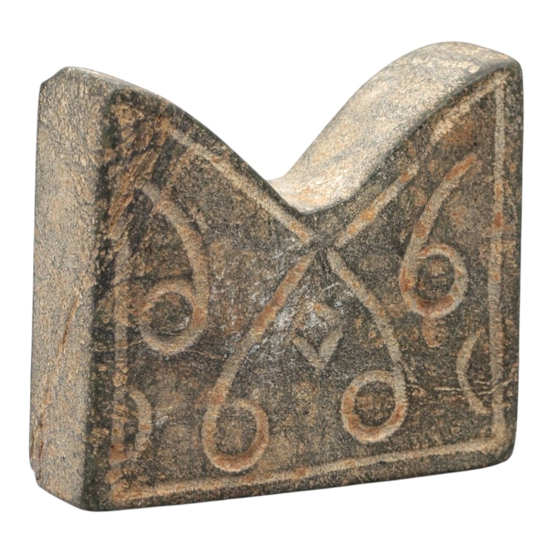 An Ancient Carved Stone Relic, 2nd-1st Millennium BCE, 30FL: Carved from dark gray stone with natural surface weathering and orange-brown incised patina, the object is formed as a block with a notched upper edge. The front face features incised curvilinear patt