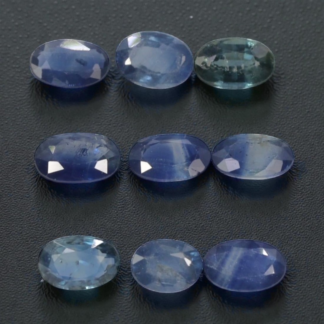 2.64 Carats Natural Multicolor Australian Sapphire Parcel - 9pcs Heated Only, 17YE: This parcel of nine natural sapphires presents a beautiful spectrum of cool tones, from deep royal blue and soft cornflower blue to subtle teal and aquamarine hues. Each oval-cut stone features faceti