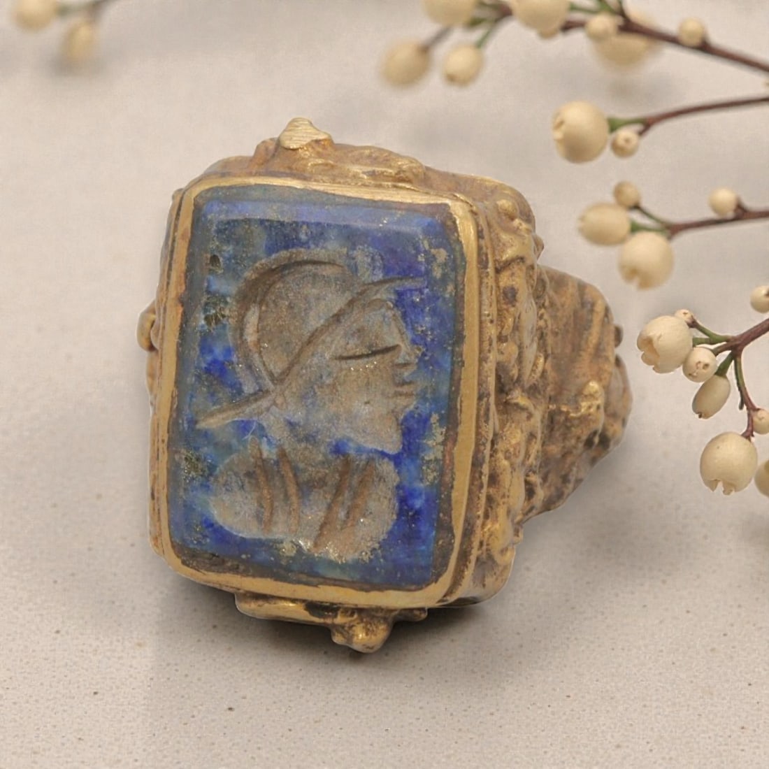Antique Qajar Dynasty Gilt Intaglio Ring, US Size 6.5, 84WS: This ring features a rectangular lapis lazuli intaglio carved with a profile bust of a figure wearing a headdress, executed in the glyptic style characteristic of Qajar period Iran. The rich blue lapi