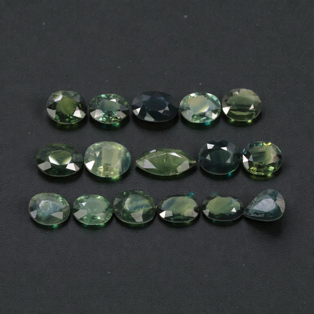 8.72 Carats Natural Multicolor Australian Green Sapphire Parcel - 16pcs Heated Only, 23YE: This extensive parcel of 16 natural sapphires showcases a rich spectrum of green hues, ranging from soft mint and pale yellow-green to deep forest green and teal tones. Each stone features a precision