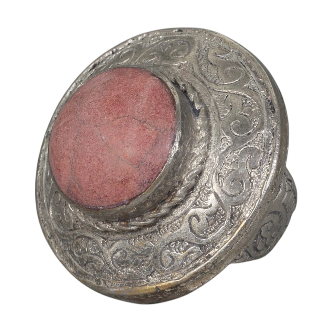 A Middle Eastern Silver Plated Rhodonite Ring, Late 19th-Early 20th Century, 36AK: The ring is centered with a large round cabochon rhodonite stone exhibiting characteristic soft pink tones and natural surface veining, set within a domed bezel accented by twisted wirework. The wide 