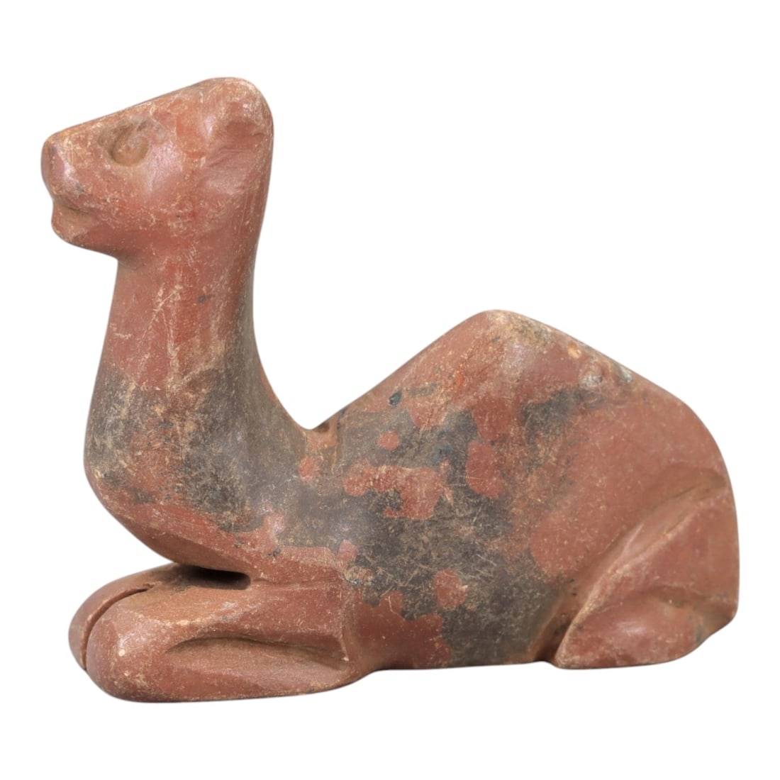 Ancient Stone Camel Effigy - Near Eastern Animal Figurine, 47AM: This camel effigy is carved from solid reddish-brown stone with natural grey veining and mineral deposits, depicting a stylized camel in a recumbent, crouched posture. The piece features clean, incise