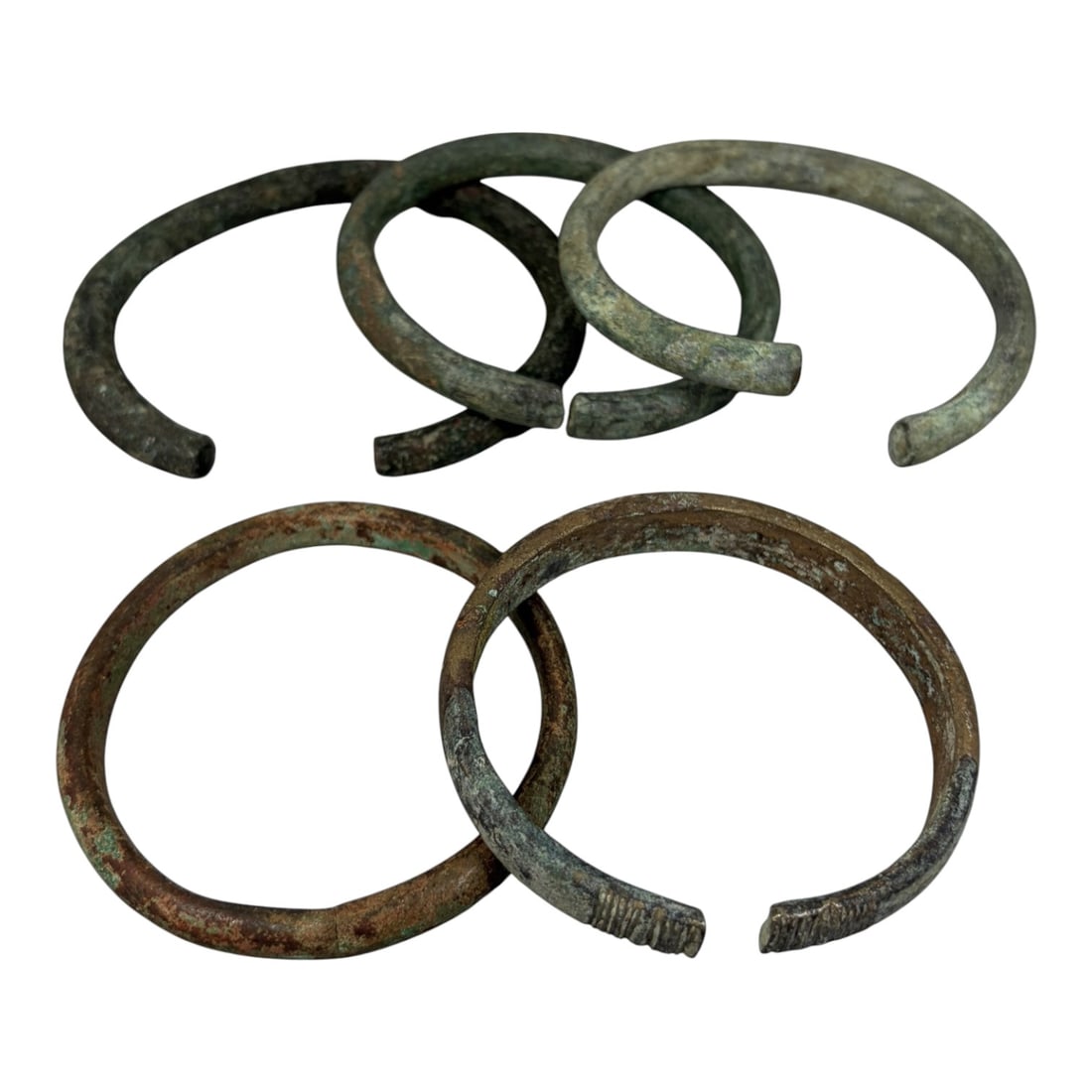 Lot of 5 Roman Bronze Bracelets, Circa 1st-4th Century CE, 91AG: A group of five open-ended bracelets crafted from bronze, exhibiting varied patination including deep green verdigris, brown oxidation, and lighter greyish surface deposits, consistent with archaeolog