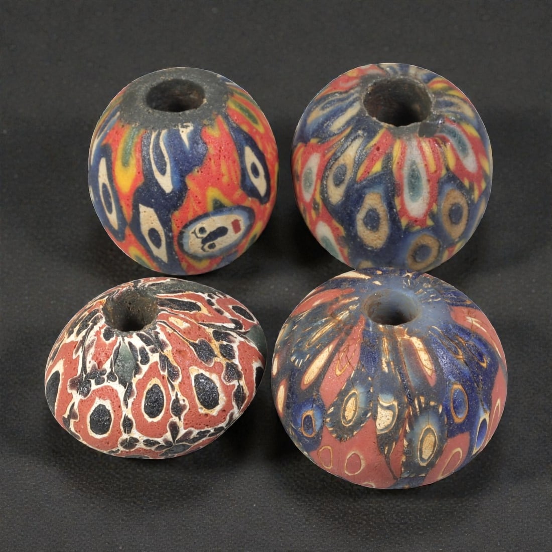 Lot of 4 Ancient to Antique Polychrome Glass Beads, 1st Mil BCE to Islamic Period, 35WM: A group of four spherical polychrome glass beads, each with a central perforation. The beads feature intricate mosaic and millefiori-style decoration, including eye motifs and composite geometric desi