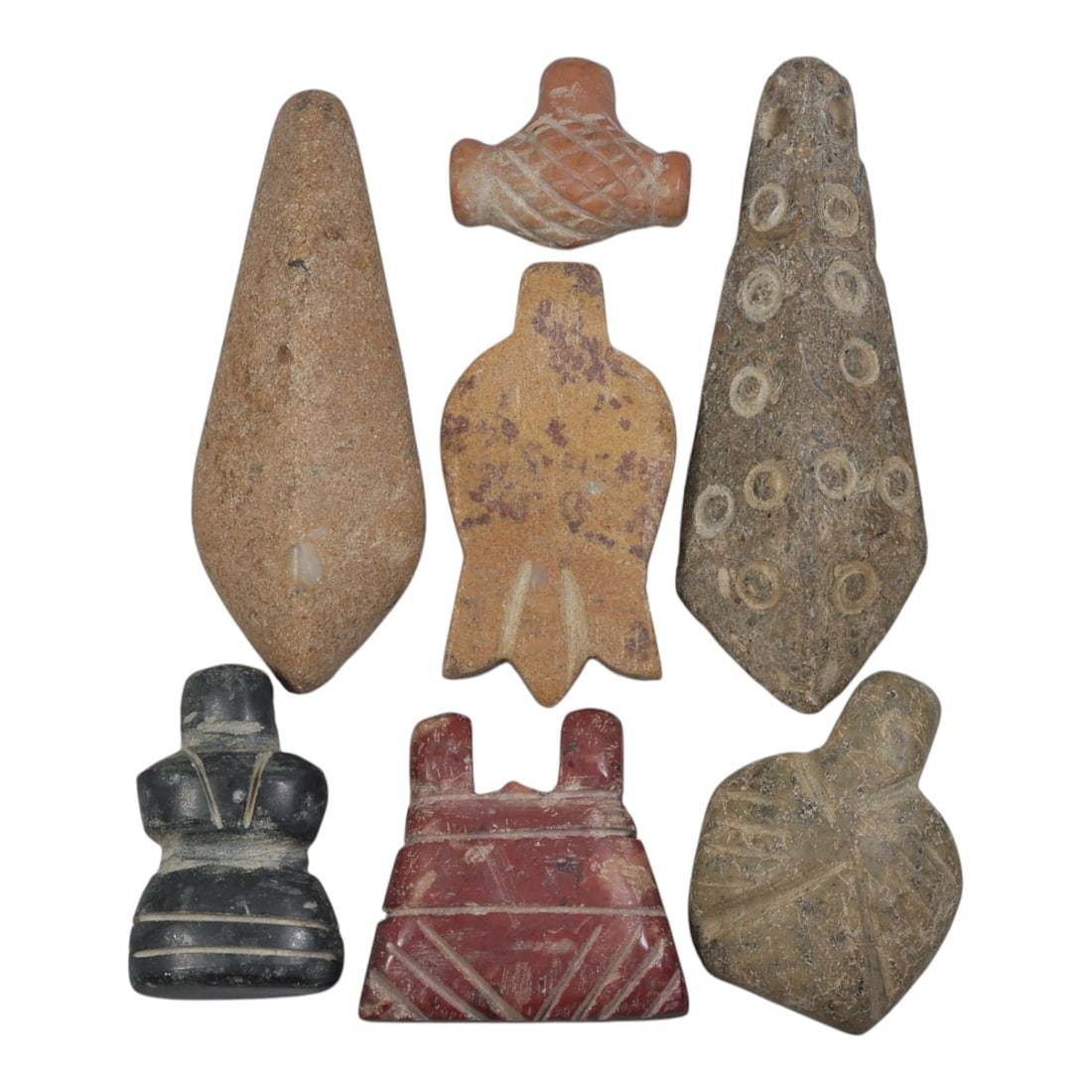 Lot of 7 Ancient Coptic Egyptian Multi-Stone Amulets, Circa Roman to Coptic Era, 93AH: Carved from various earth-toned stones including sandy beige, reddish-brown, dark grey, and speckled varieties, the group consists of seven distinct amulets, ranging in size from 1.5 cm to 5.5 cm (0.5