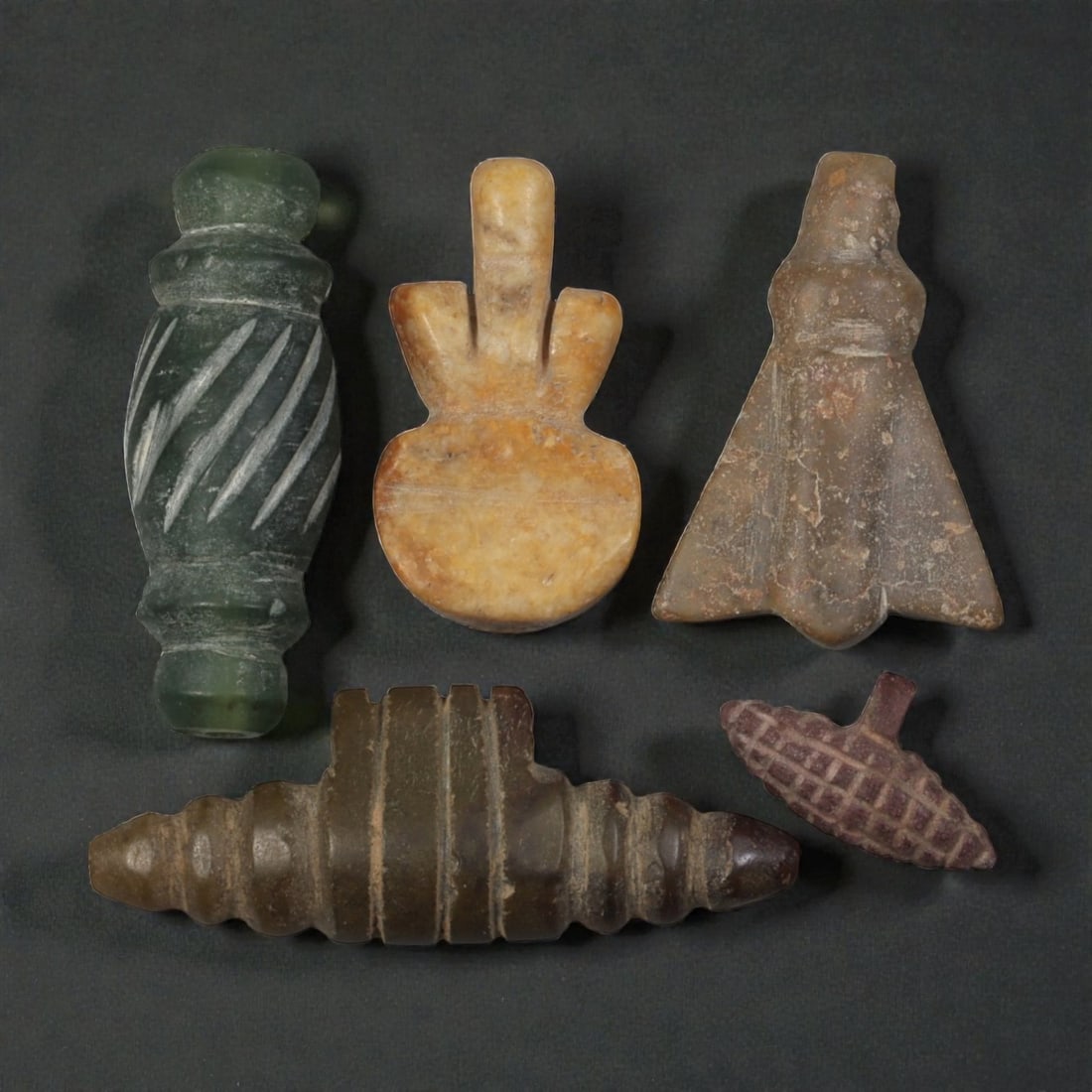 Lot of 5 Ancient Coptic Egyptian Stone Amulets, Circa Roman to Coptic Era, 96WP: Carved from various stones, including green, tan, brown, and reddish varieties, the group consists of five amulets of distinct forms. The set includes a spirally incised barrel bead, a double-plumed s