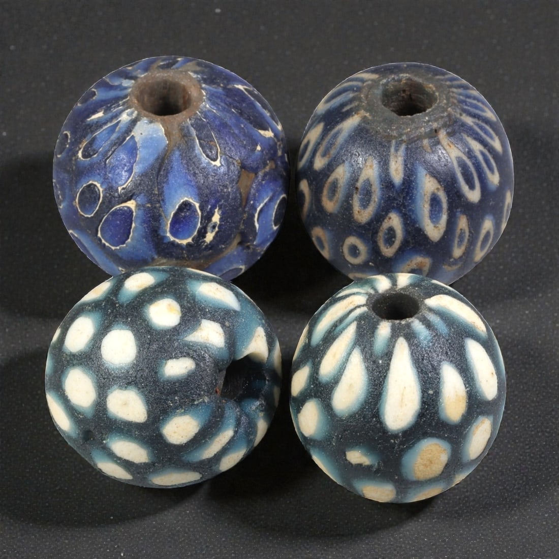 Lot of 4 Ancient to Antique Polychrome Glass Beads, 1st Mil BCE to Islamic Period, 38WM: A group of four spherical polychrome glass beads, each with a central perforation. The beads feature intricate mosaic and millefiori-style decoration, including eye motifs, dot patterns, and composite